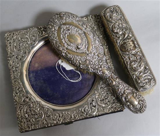 A Edwardian repousse silver photograph frame, Birmingham, 1903 and two brushes.